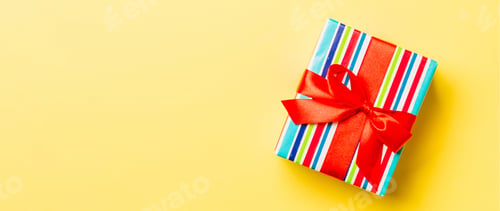 Preview: Top view Christmas present box with red bow on yellow background with copy space