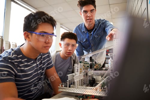 Preview: Teacher With Two Male College Students Building Machine In Science Robotics Or Engineering Class