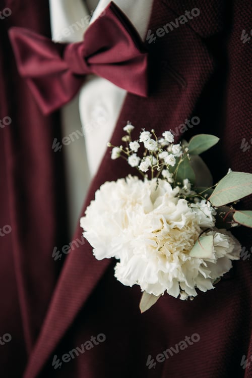 Preview: close up view of buttonhole and grooms suit with bow tie for rustic wedding