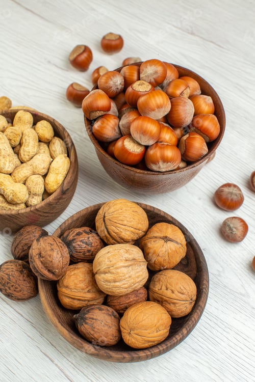 Preview: front view different nuts peanuts hazelnuts and walnuts on white background photo snack seed movie