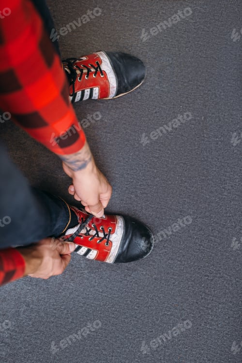 Preview: Bowler ties shoelaces on house shoes, top view