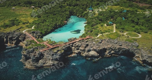 Preview: Cliff sea coastline with green landscape, limpid lake on top in aerial view. Scenic tropic seascape