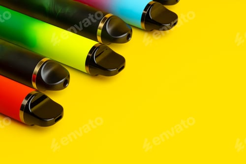 Preview: Colorful disposable electronic cigarettes on yellow background