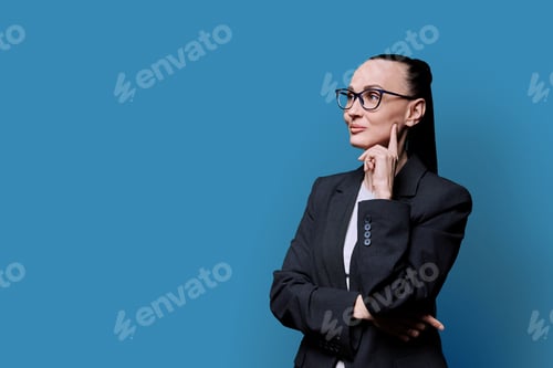 Preview: Portrait of thinking serious confident business woman , on blue studio background
