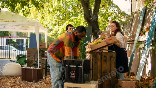 Preview: Deliveryman holding backpack near farmers market counter