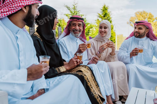 Preview: Middle eastern muslim family enjoying tea and togetherness outdoors
