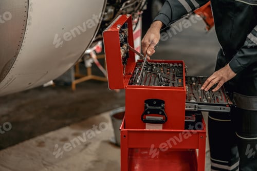 Preview: Male mechanic using instrument box in hangar
