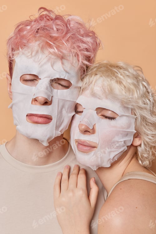 Preview: Vertical shot of calm relaxed woman and man apply facial sheet masks for skin treatment keep eyes