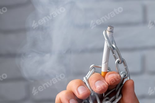 Preview: Male hand in metal chains holding cigarette