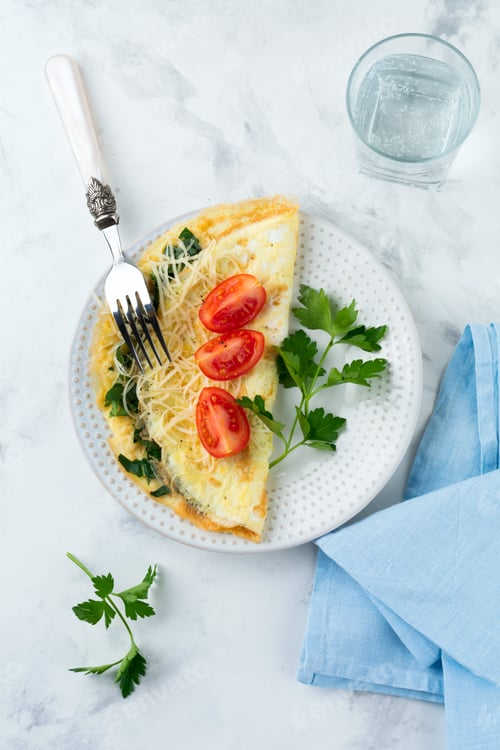 Aperçu: Omelet with spinach, parsley and cheese for breakfast on a light background. Selective focus