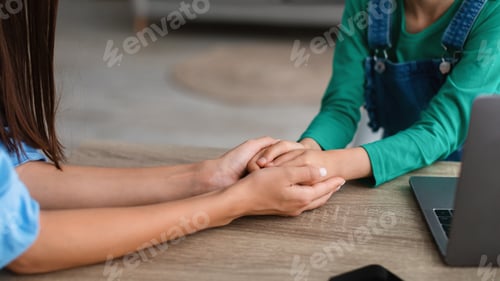 Preview: Closeup of mother and daughter holding hands