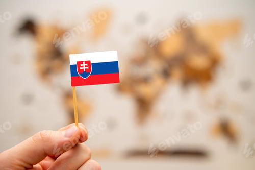 Preview: Slovakia flag in mans hand on the world map background.