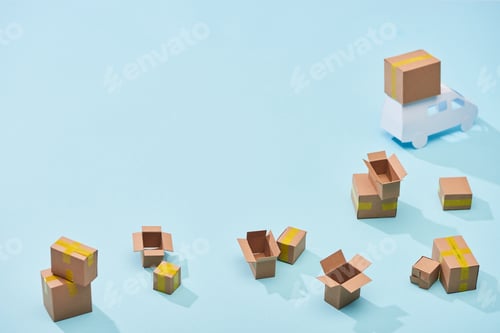 Preview: scattered cardboard boxes near mini truck on blue background with copy space