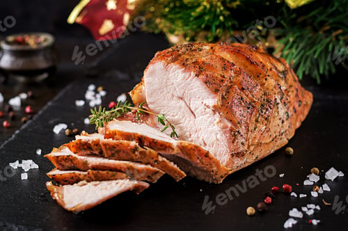 Preview: Roasted sliced Christmas ham of turkey on dark rustic background. Festival food.