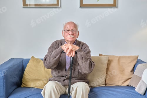 Preview: Senior man sitting on sofa and resting