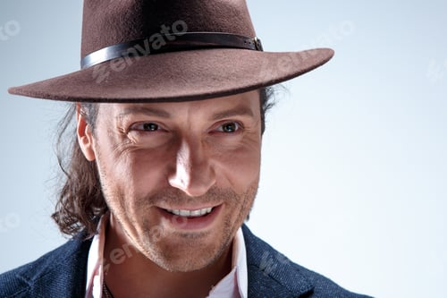 Preview: Young Man Portrait With Hat On Gray Studio Background.