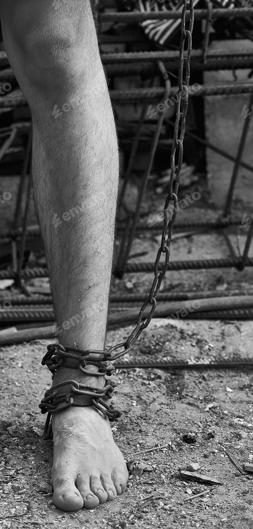 Preview: Close-up shot of barefoot legs tied up with old chain