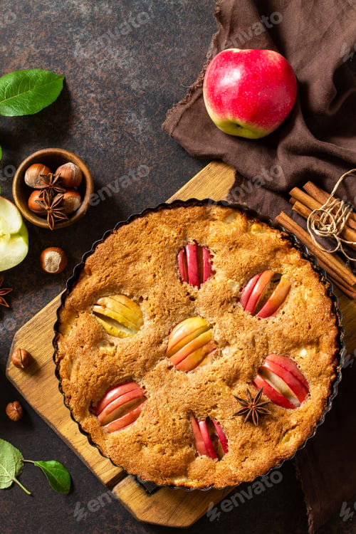 Preview: Apple baking seasonal. Apple pie with hazelnut and cinnamon on a rustic wooden table.