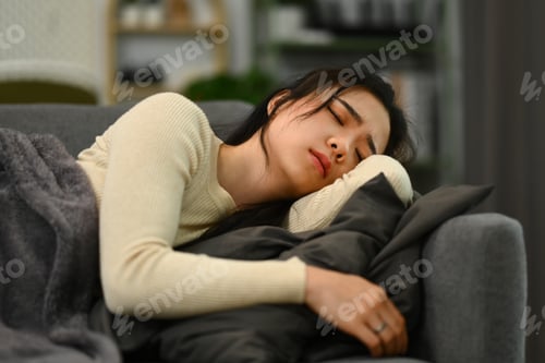 Preview: Sick woman lying on couch under blanket feeling exhaustion, suffering from headache, flu symptom
