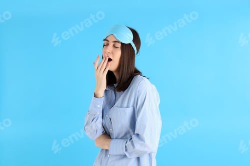 Preview: Attractive woman in sleep mask on blue background
