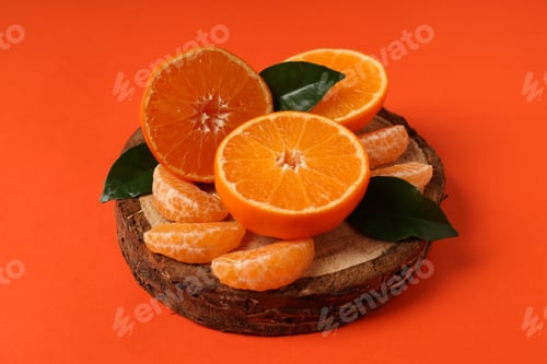 Preview: Board with mandarin and leaves on orange background