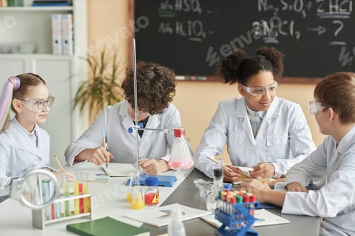 Preview: Group of schoolchildren wearing lab coats during science experiment class