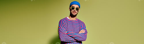Preview: Handsome young man shows off vibrant sunglasses and stylish outfit in studio setting