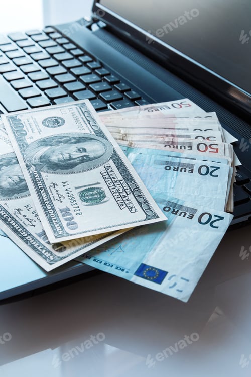 Preview: Banknotes over laptop keyboard