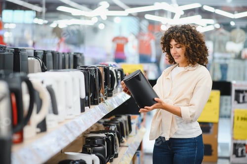 Preview: Woman choosing kettle in home appliances store