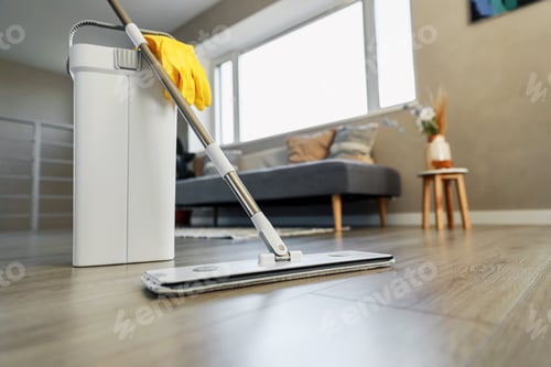 Preview: Cleaning supplies: mop, gloves, bucket with wringer on wooden laminate floor