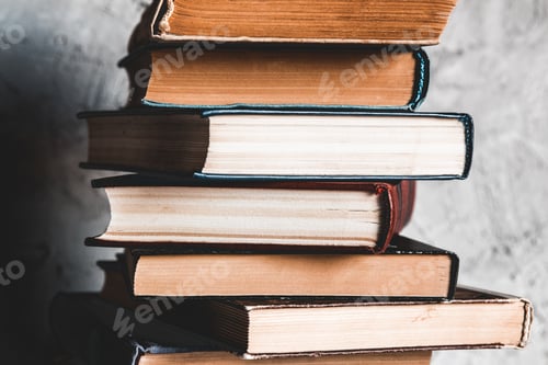 Preview: Education and reading concept, group of old colorful books on the white table on the gray background