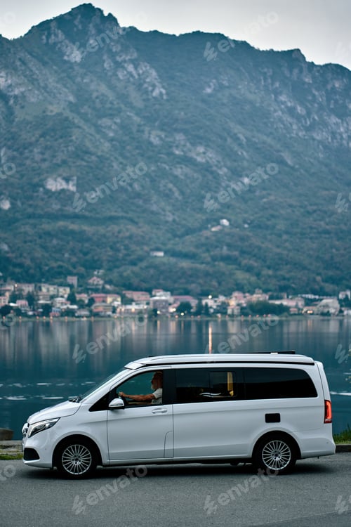 Preview: Older man driving camper van on nature mountains background.