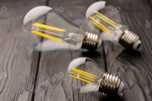 Preview: Light bulbs on dark wooden background close up