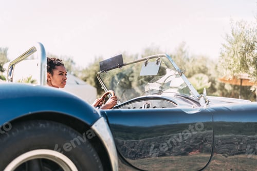 Preview: Black woman driving a vintage convertible car