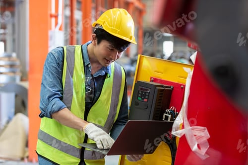 Preview: asian man engineer technical department using laptop working in power plant control panel of industr