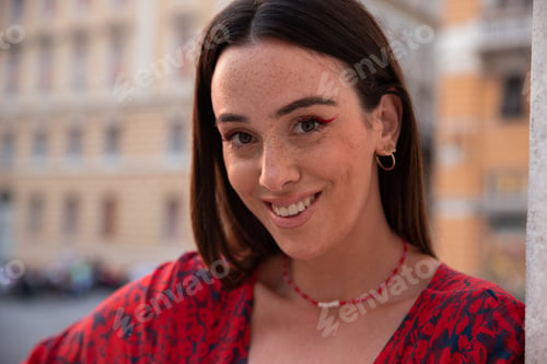 Preview: Young girl with freckles smiles outside in downtown looking confidently ahead