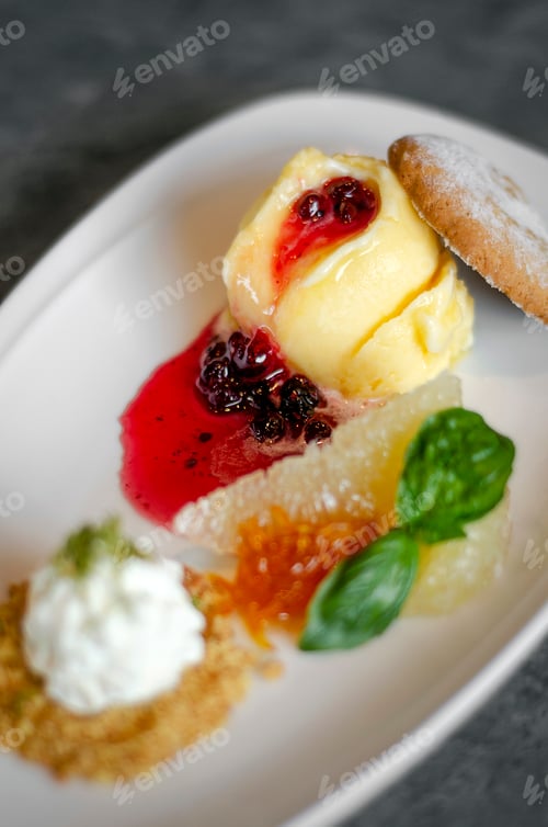 Preview: gourmet mango ice cream with redcurrant sauce dessert on plate