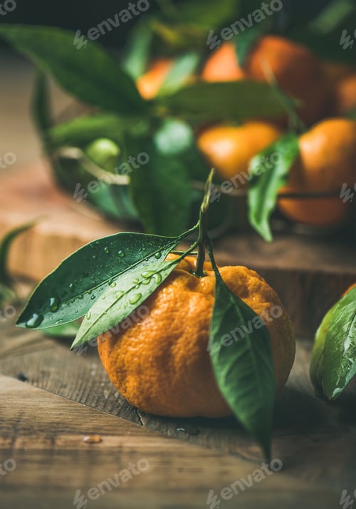 Preview: Fresh tangerine with leaves over wooden background, close-up