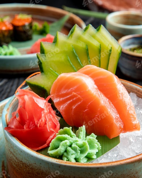 Preview: side view of salmon sashimi with sliced cucumbers ginger and wasabi sauce