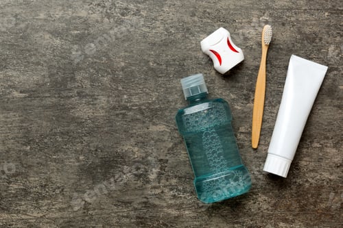 Preview: Mouthwash and other oral hygiene products on colored table top view with copy space.