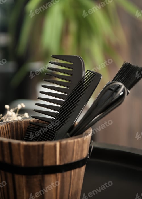 Preview: Hairdressing tools combs close-up in a wooden vase