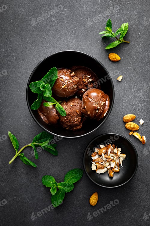 Preview: Chocolate ice cream with almonds served in bowl on black background, top view