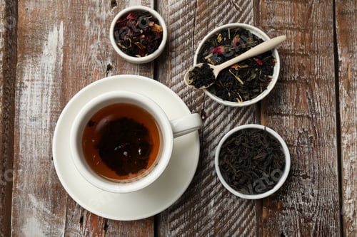 Preview: Aromatic tea and dried leaves on wooden table, flat lay