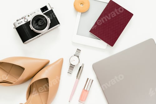 Preview: Flat lay of a woman's office desk, featuring a laptop, a notebook and various accessories