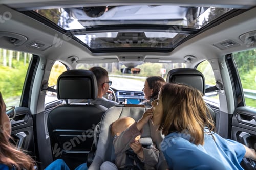 Preview: Laughter on the move inside car. Baby feeds sister during family trip