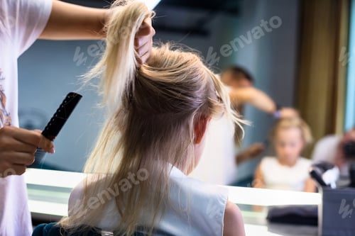 Preview: Hairdresser woman hands combing hair with comb child in barbershop, close-up