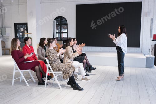 Visualização: Vista lateral das pessoas que ouvem o treinador discursando no treinamento de negócios