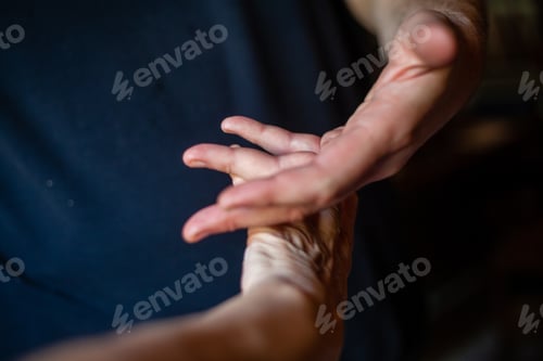 Preview: Elderly Caucasian hand holding young man hand