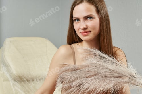 Preview: Young Woman Posing with Ornamental Grass Indoors
