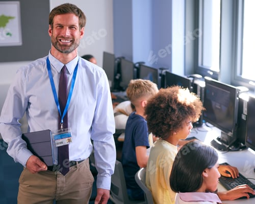 Preview: Portrait Of Male Secondary Or High School Teacher With Students At Computers In IT Class